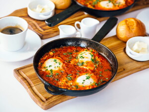 Huevos cazuelas en salsa de tomate dentro de una sarten de color negro