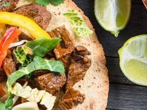 Fajitas rellenas con res y una salsa con limones a un lado