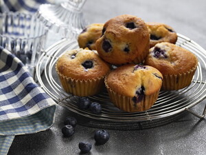 Varios cupcake de moras encima de un soporte decorativo