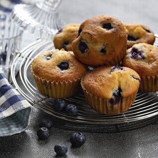 Varios cupcake de moras encima de un soporte decorativo