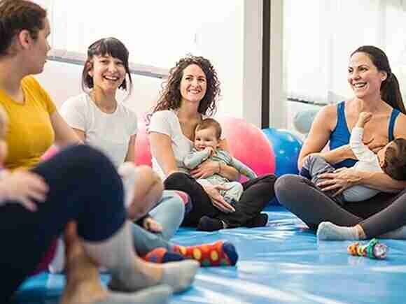 Grupo de madres reunidas con sus bebés en clase grupal
