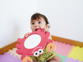 Representación de los síntomas cuando salen los dientes a los bebés en un escenario en el que el pequeño está mordiendo un juguete