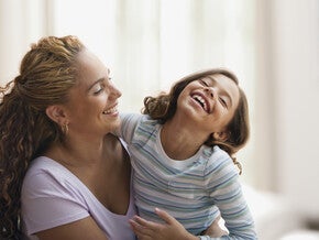 Mamá y niña de preescolar riendo al decir trabalenguas