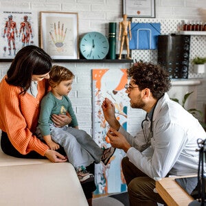 Pediatra revisando a niña con estomatitis