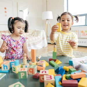 Grupo de niños preescolares riendo y jugando juntos, mostrando interacción social positiva.