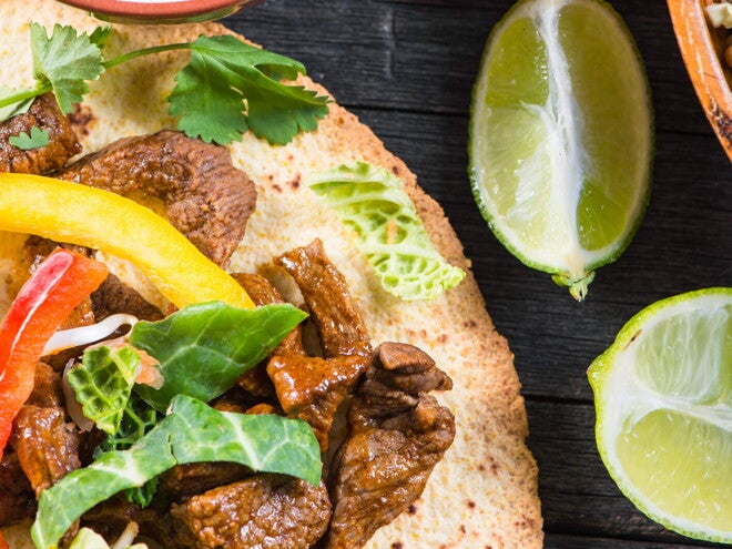 Tostadas de Fajitas de Res con Guacamole Fajitas rellenas con res y una salsa con limones a un lado