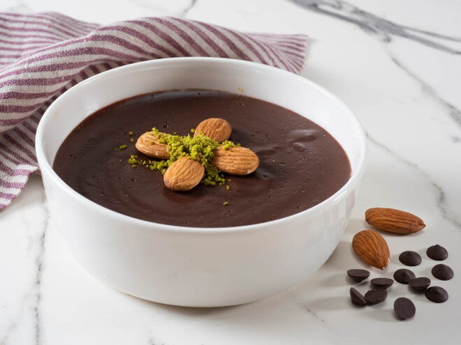 Budín de Tapioca con Almendras Un bowl que contiene budin de chocolate con decoración de almendras