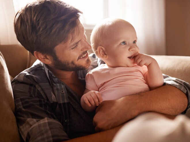 Un bebé con su padre generando apego emocional seguro.