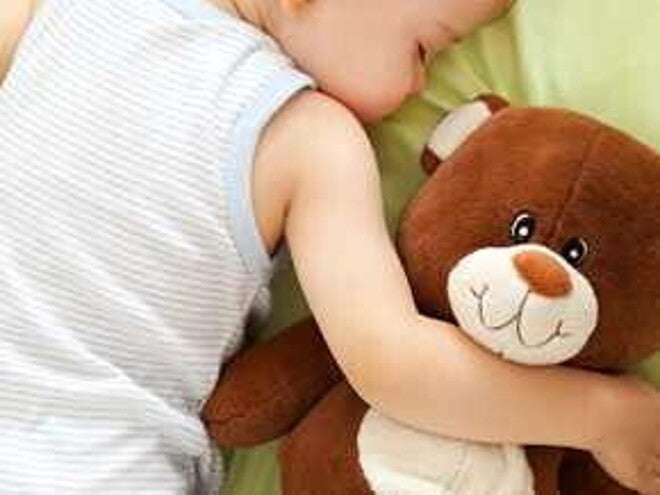 Bebé durmiendo boca abajo abrazando su osito de peluche Bebé durmiendo boca abajo abrazando su osito de peluche