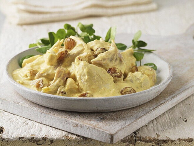 En un plato se encuentra una porción de pollo con una salsa cremosa y ensalada verde a un lado En un plato se encuentra una porción de pollo con una salsa cremosa y ensalada verde a un lado