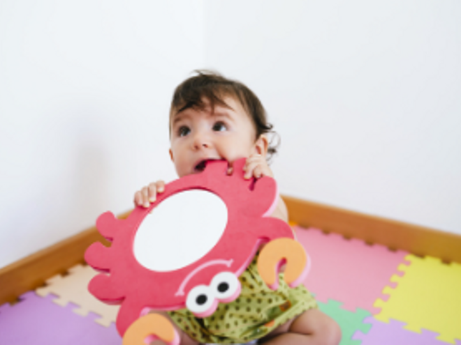 Representación de los síntomas cuando salen los dientes a los bebés en un escenario en el que el pequeño está mordiendo un juguete