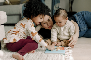 Madre enseña a leer a sus hijos.