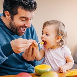 Padre dandole de comer a su hija Padre dándole de comer a su hija
