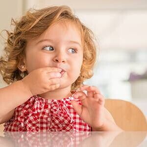 Niña comiendo con la mano Niña comiendo con la mano
