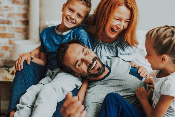 Familia, papá, mamá, hijo e hija riendo al decir trabalenguas