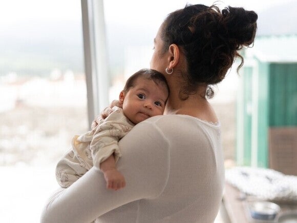 Mamá sosteniendo a su bebé sobre el hombro para ayudarle a eructar