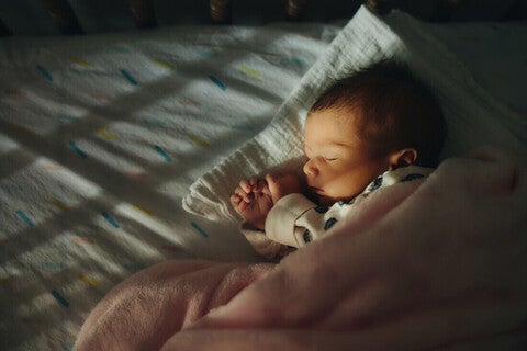 Bebé pequeño durmiendo en su cuna. Sueño infantil.